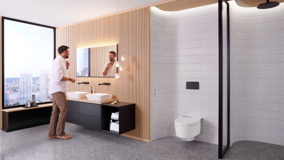 Homem na casa de banho em frente ao espelho Geberit Option Plus Square e ao armário de casa de banho preto Geberit ONE (© Geberit) Homem na casa de banho em frente ao espelho Geberit Option Plus Square e ao armário de casa de banho preto Geberit ONE (© Geberit)