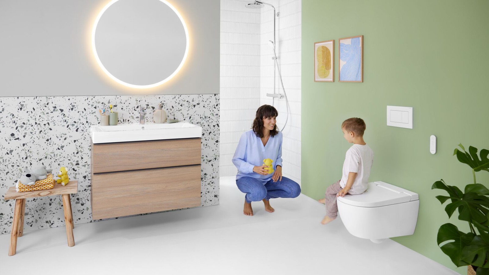 Mulher e criança numa casa de banho colorida com Geberit Option e espelho Geberit AquaClean Alba Mulher e criança numa casa de banho colorida com Geberit Option e espelho Geberit AquaClean Alba