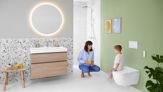 Mulher e criança numa casa de banho com sanita bidé Geberit AquaClean Alba Mulher e criança numa casa de banho com sanita bidé Geberit AquaClean Alba
