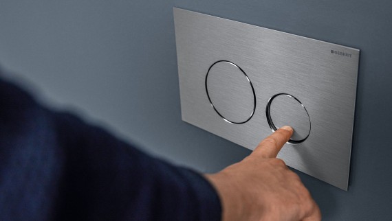 Mão que ativa a descarga da placa Sigma40 Round (© Geberit) Mão que ativa a descarga da placa Sigma40 Round (© Geberit)