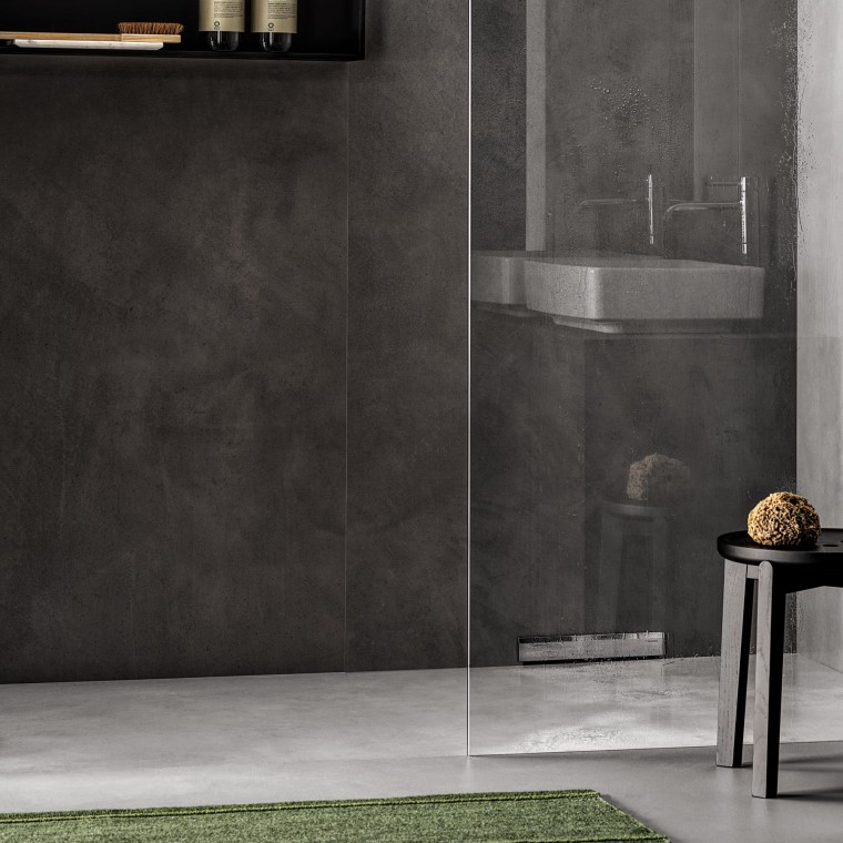 Um duche ao nível do chão com drenagem na parede Um duche ao nível do chão com drenagem na parede