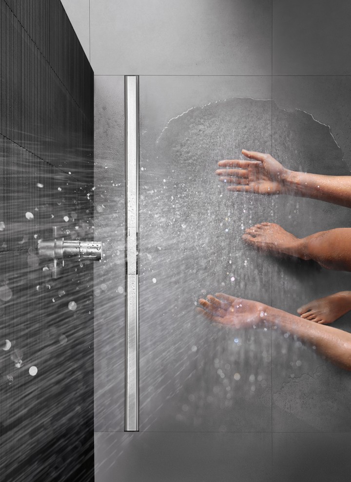 Pessoa a tomar um duche num duche ao nível do chão com canal de duche CleanLine (© Geberit)