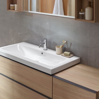 Área de lavatório com móveis de casa de banho feitos em madeira da série Geberit iCon