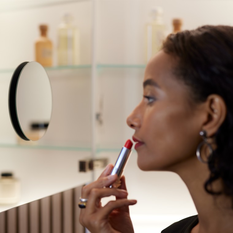 Mulher a maquilhar-se ao espelho