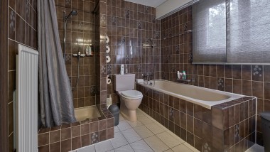 Casa de banho com espaço de duche estreito, banheira e WC no chão
