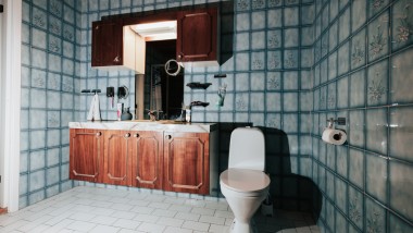 Casa de banho com azulejos azuis e WC no chão