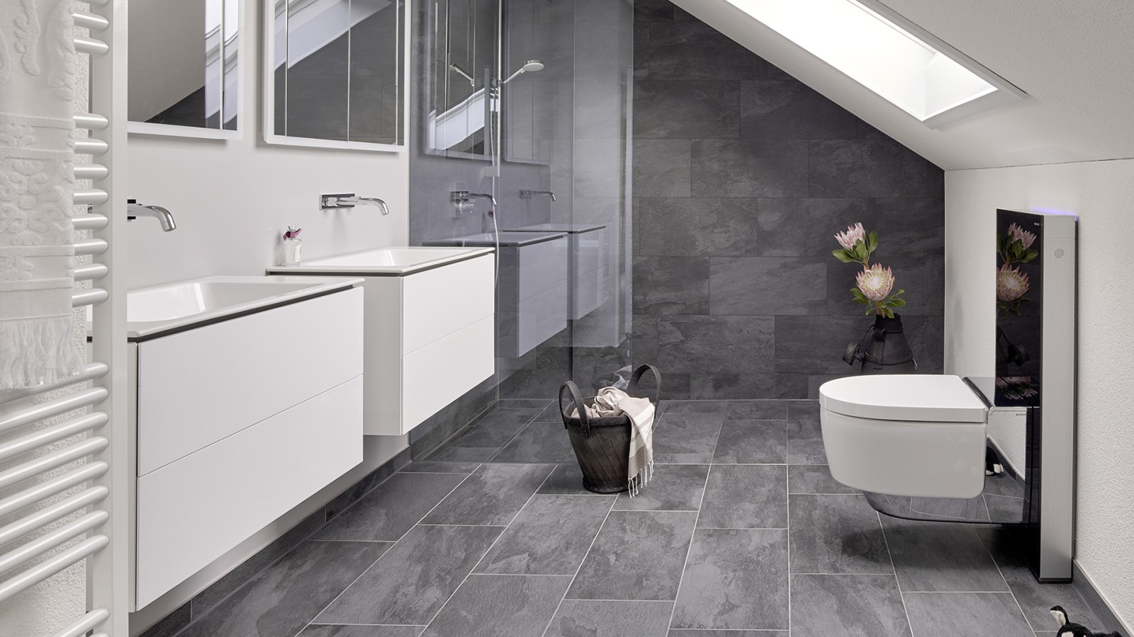 Casa de banho com cobertura inclinada e produtos da série de casas de banho Geberit ONE e Geberit AquaClean com Monolith Casa de banho com cobertura inclinada e produtos da série de casas de banho Geberit ONE e Geberit AquaClean com Monolith