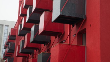 Uma apelativa fachada vermelha presidida por varandas cúbicas é o novo ponto de atração em Goldsteinstrasse, Frankfurt (DE) (© Geberit)