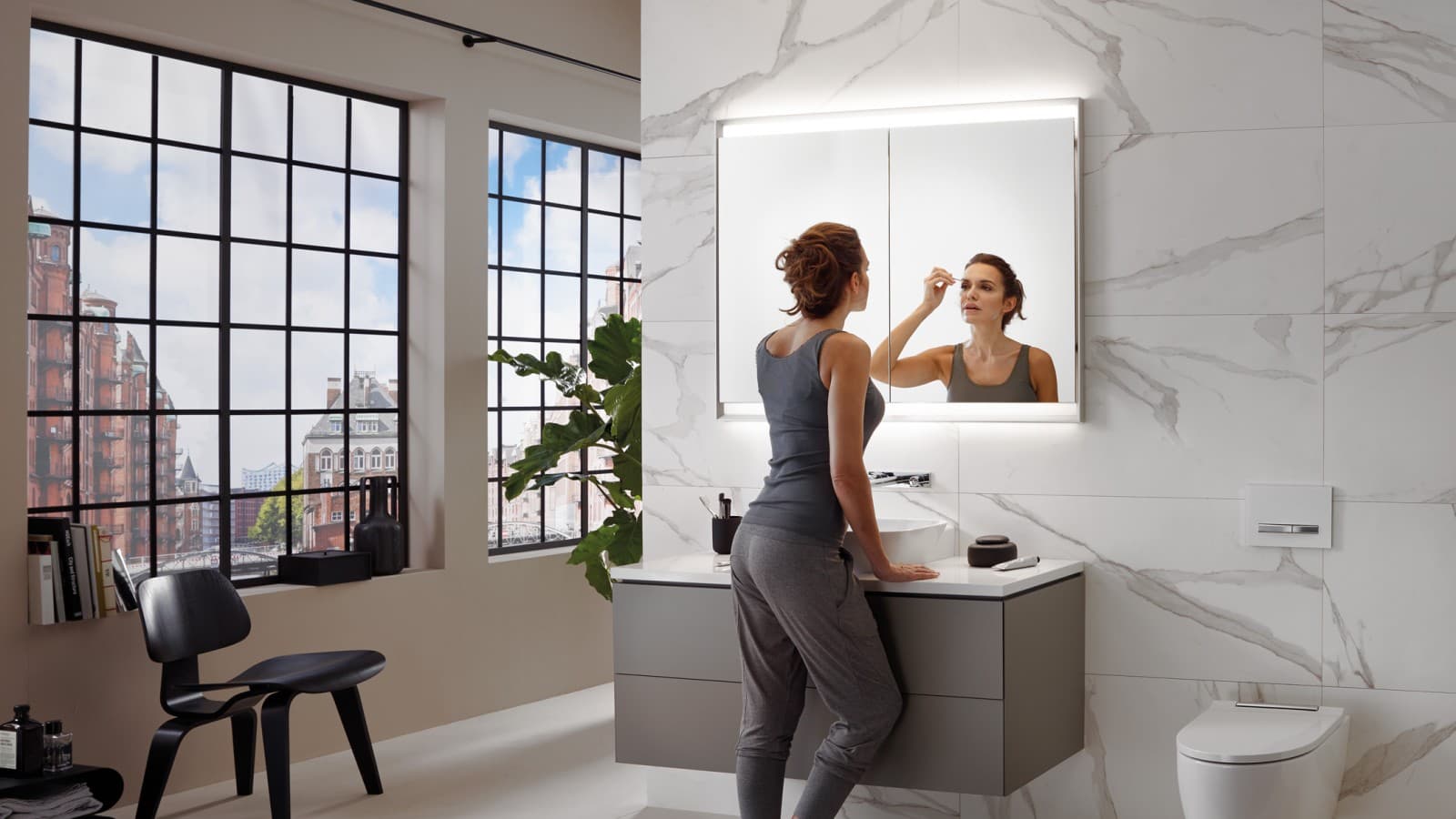 Mulher numa casa de banho com Geberit ComfortLight Mulher numa casa de banho com Geberit ComfortLight