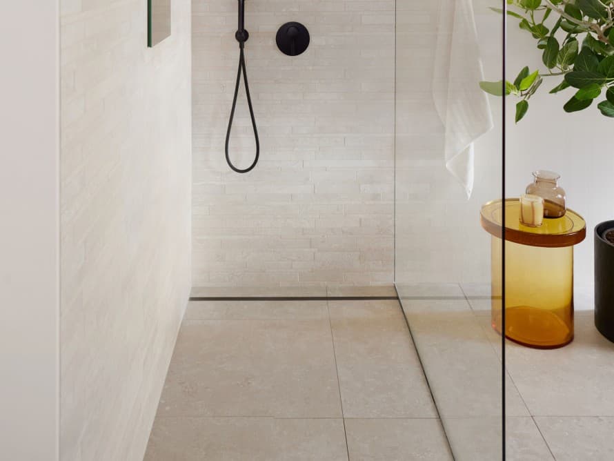 Casa de banho com azulejos grandes e duche ao nível do pavimento