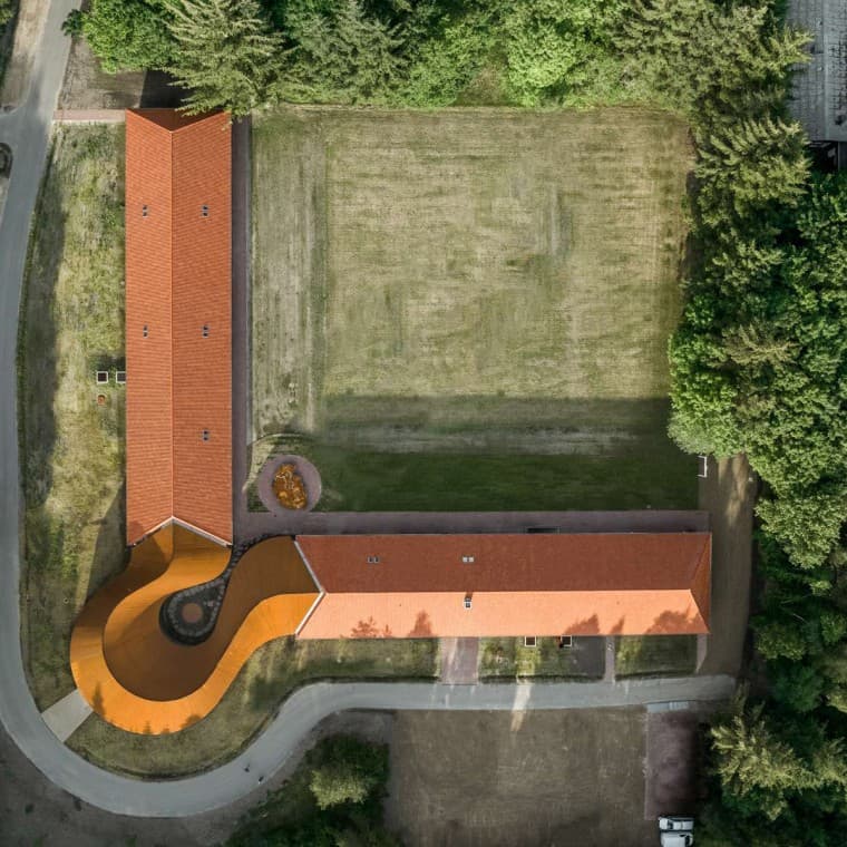 A vista desde cima mostra o novo edifício redondo que liga os dois edifícios históricos com as coberturas de telhas (© R_Hjortshoj) A vista desde cima mostra o novo edifício redondo que liga os dois edifícios históricos com as coberturas de telhas (© R_Hjortshoj)